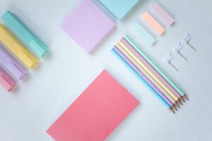 Flat lay of pastel stationery items including pencils and sticky notes, perfect for back to school themes.
