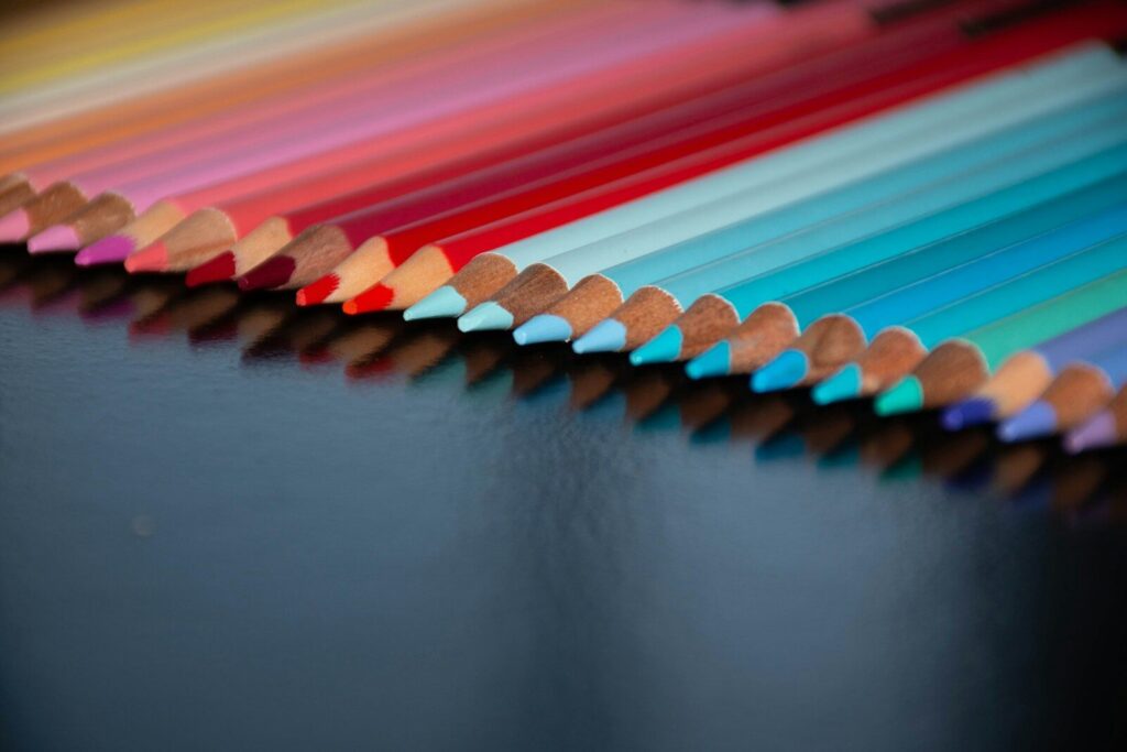 a row of colored pencils sitting on top of a table