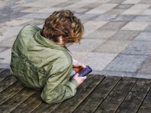 Safe Christian Apps for Teens; Young person with curly hair using a smartphone.