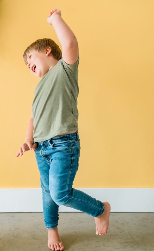 music and movement; boy in gray t-shirt and blue denim jeans